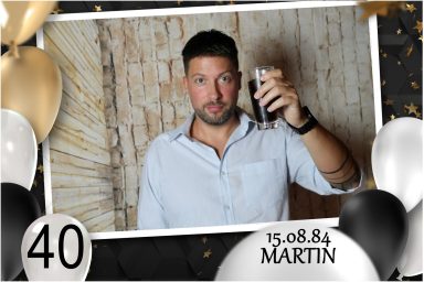 Mann hebt das Glas bei Martins 40. Geburtstag, aufgenommen mit Fotobox.